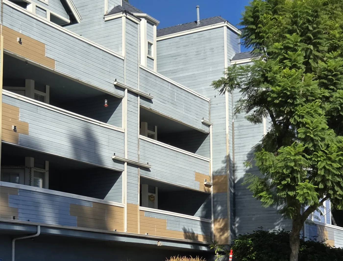 Apartment facade mid-repaint with primer patches